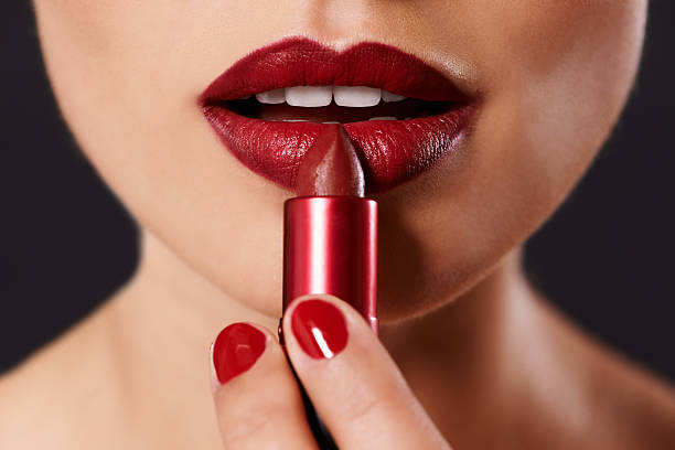 a woman applying lipstick