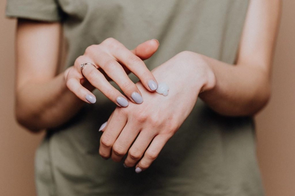 A woman creams her hands.