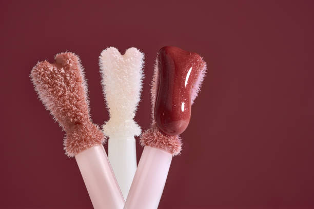 Three color gloss lipstick Brushes isolated on colorful background. Macro shot